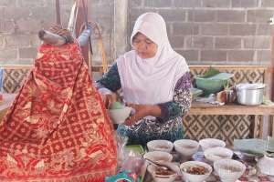 Bu Sri menyiapkan sajian soto ayam dan sate kerang 
