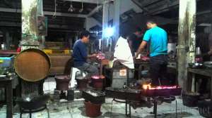 Pak Bari dan asistennya menyiapkan sate klathak yang dibakar dengan tusuk jeruji sepeda